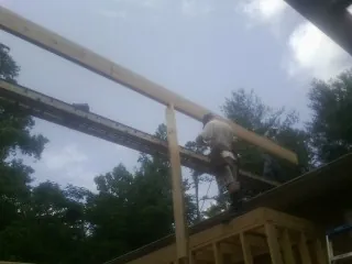 Carpenter setting a ridge beam over a new addition frame — Ice Dam Removal by Roofing Brothers in Lumberville