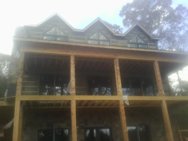 Dormers and porch framing on a large log home under construction — Roof Coating work by our crew in Lumberville