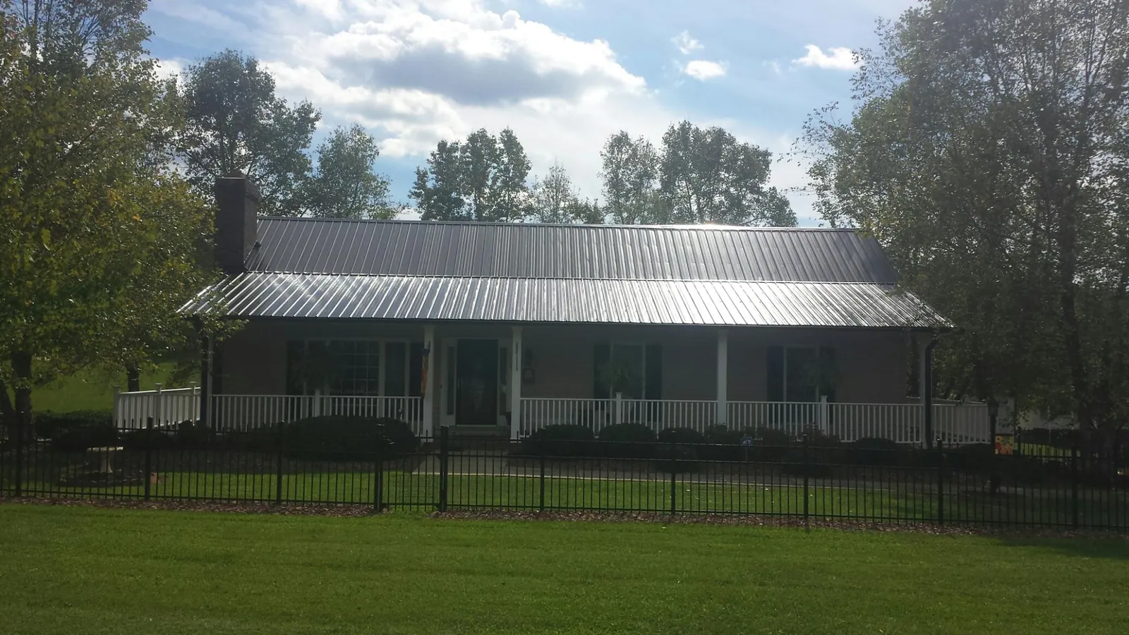 Gray metal roof on a brick ranch with a full width front porch — Gutter Guard Installation work by our crew in Lumberville