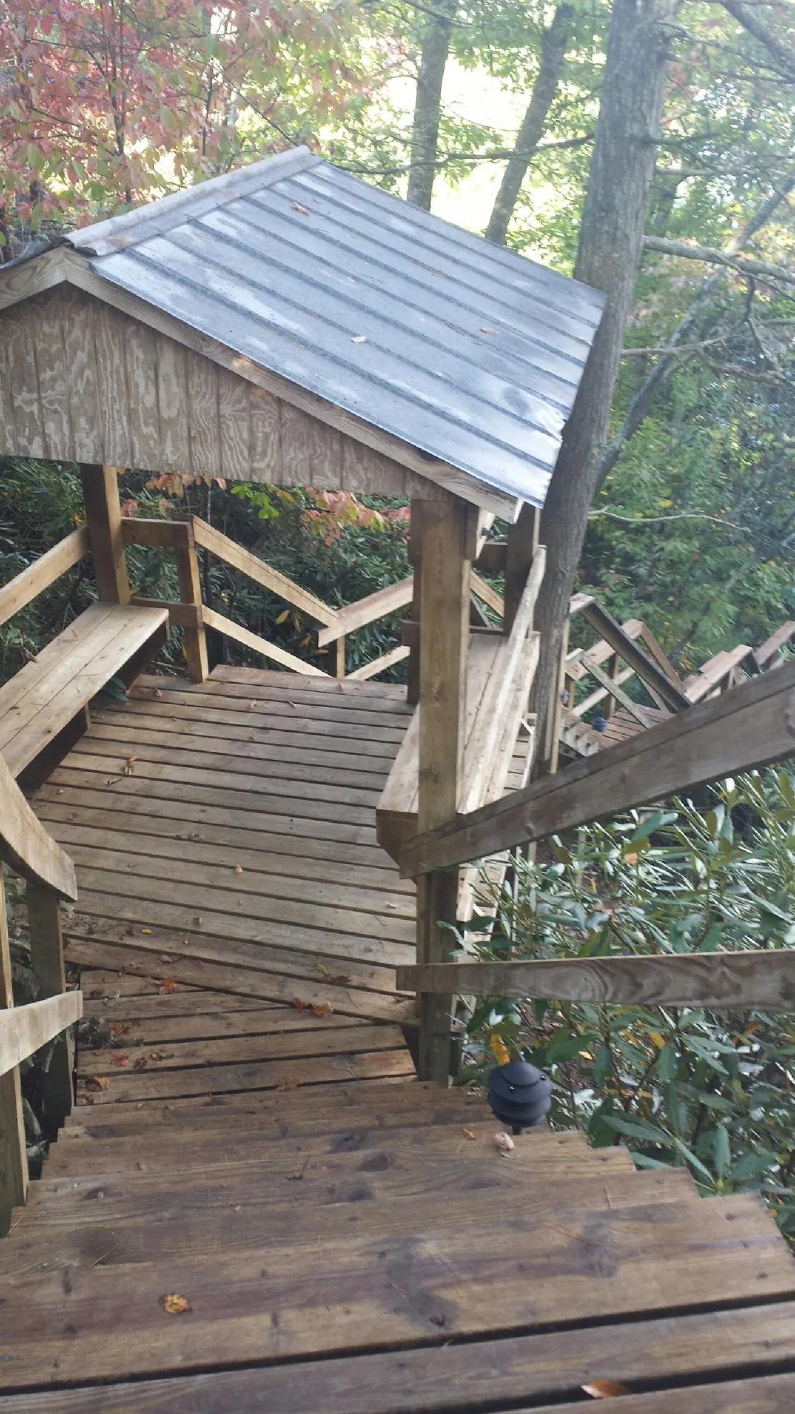 Metal roofed shelter over wooden steps on a wooded walkway — Skylight Repair & Installation work by our crew in Lumberville