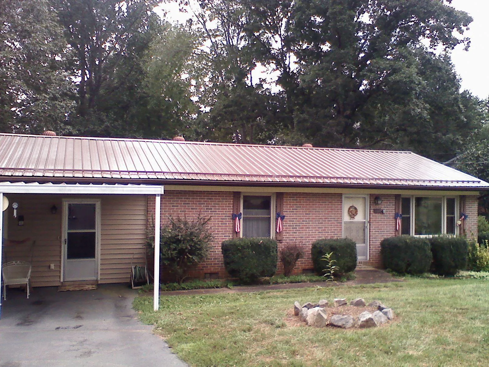 Bronze metal roof and carport on a brick ranch home — Roof Repair work by our crew in Lumberville